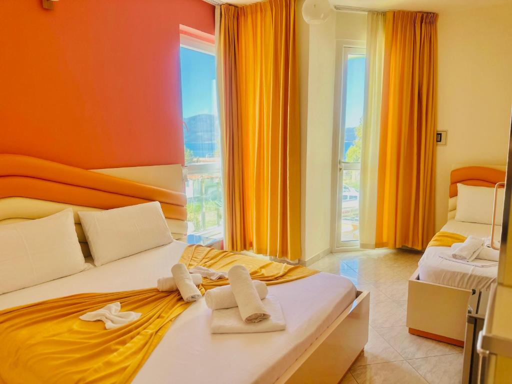 a hotel room with two beds with towels on them at Hotel Garden in Vlorë