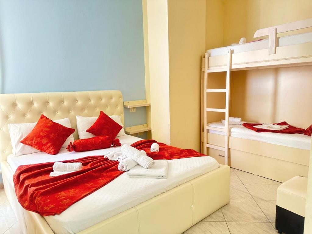 a bedroom with two bunk beds with red pillows at Hotel Garden in Vlorë