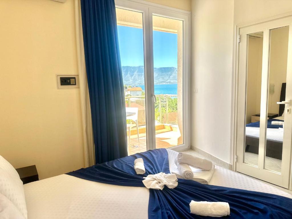 a bedroom with a bed with a view of the ocean at Hotel Garden in Vlorë