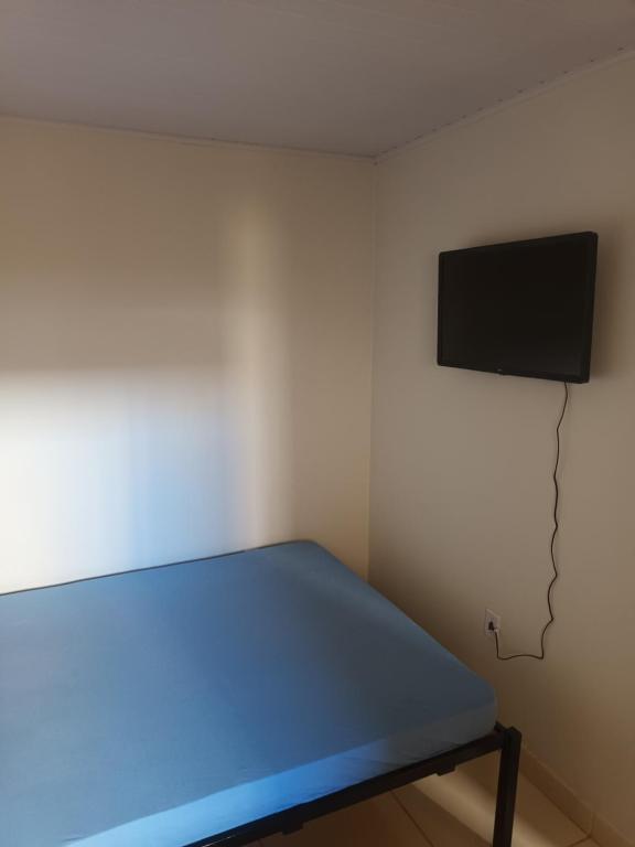 a room with a bed and a tv on the wall at Apto 4 ótimo local próximo shopping in Campo Grande