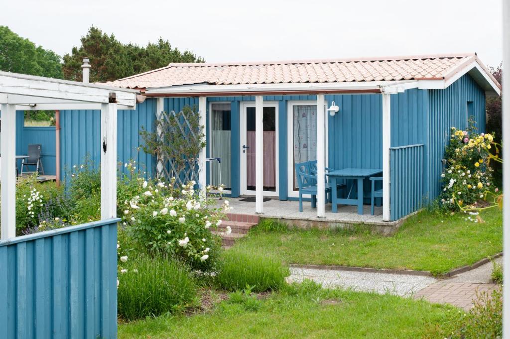 a blue cottage with a porch at Möve Aba Bungalow 65 in Rerik