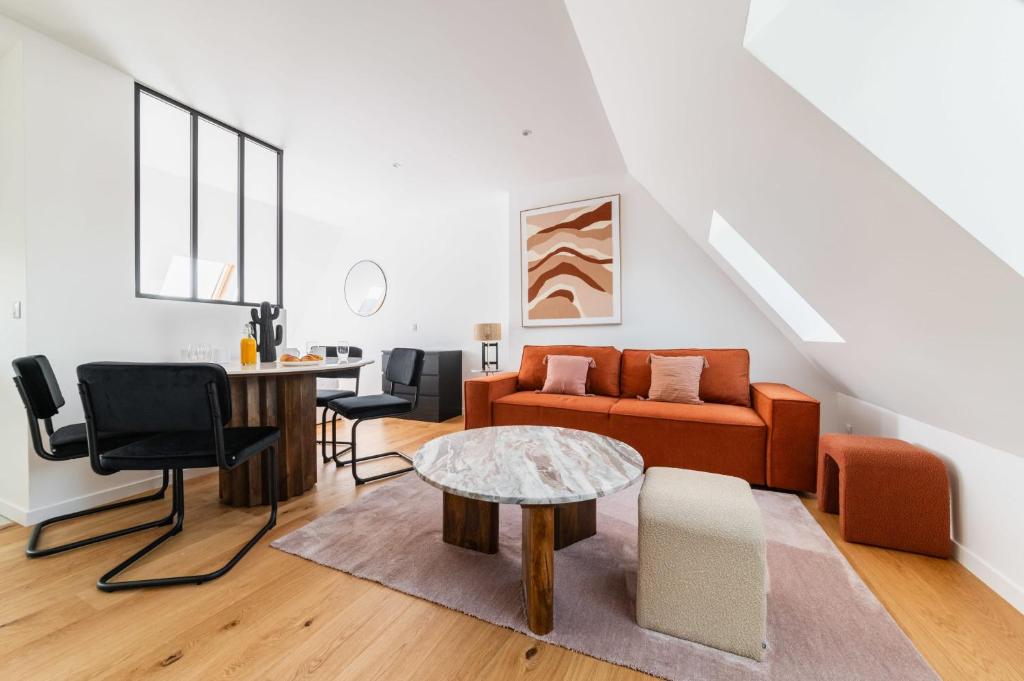 un salon avec un canapé et une table dans l'établissement 2 pieces refait a neuf dernier etage - Paris 19 - 4P - FLAT-GUEST, à Paris