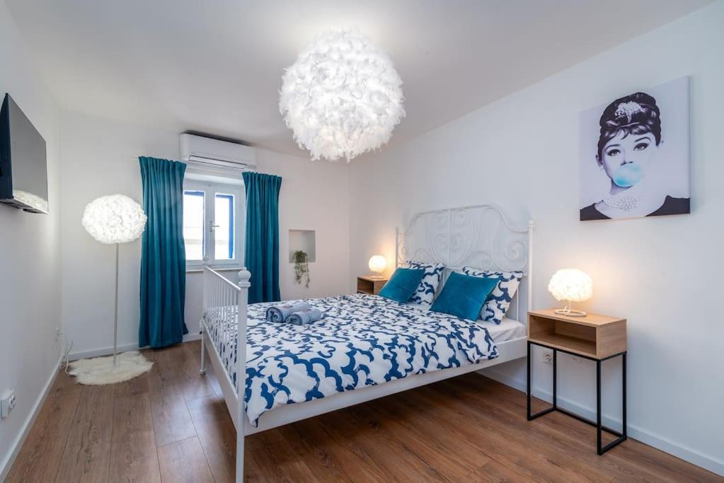 a bedroom with a bed and a chandelier at Duplex apartment Domi in Slatine