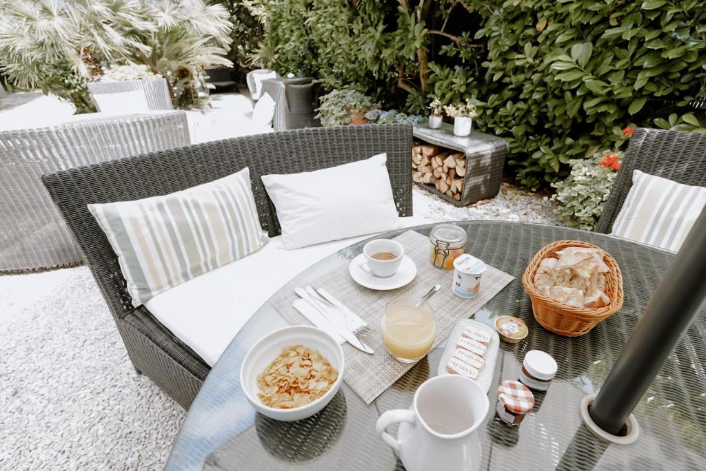 una mesa al aire libre con comida y bebidas. en Idéal Séjour - Boutique Hôtel Cosy, en Cannes