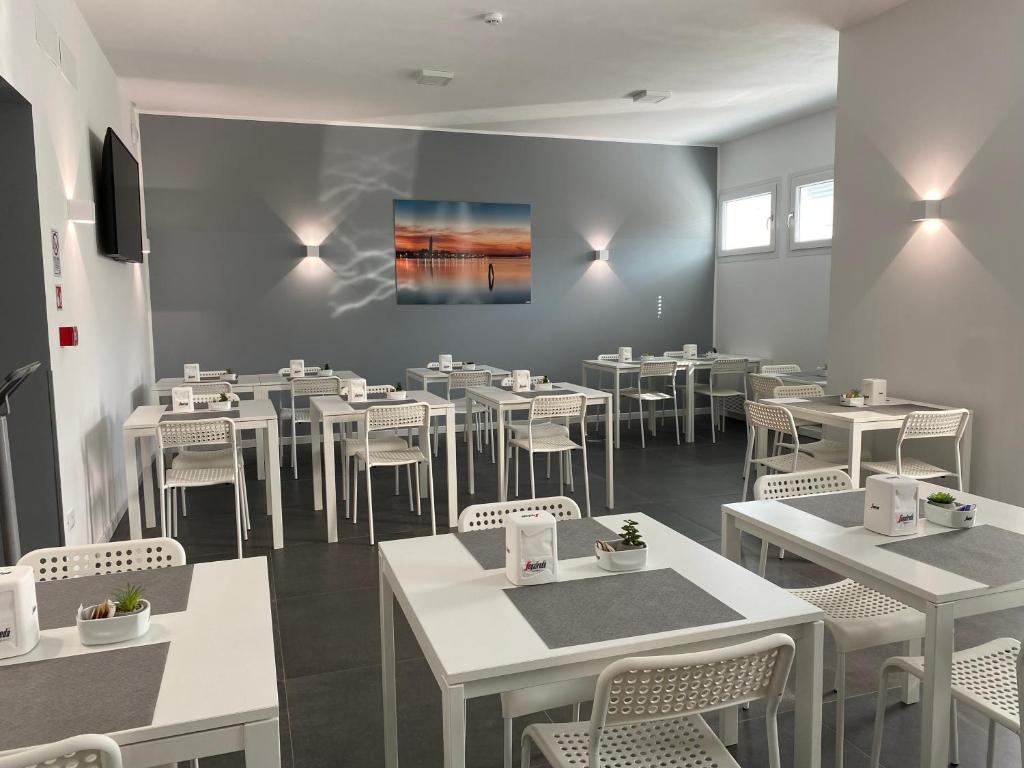 a dining room with white tables and white chairs at Boutique Hotel Nuovo Cason in Cavallino-Treporti