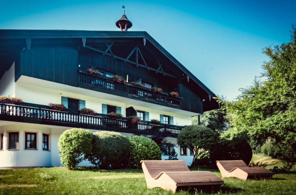 a building with two benches in front of it at Gschwendtnerhof App23 Christ in Aschau im Chiemgau
