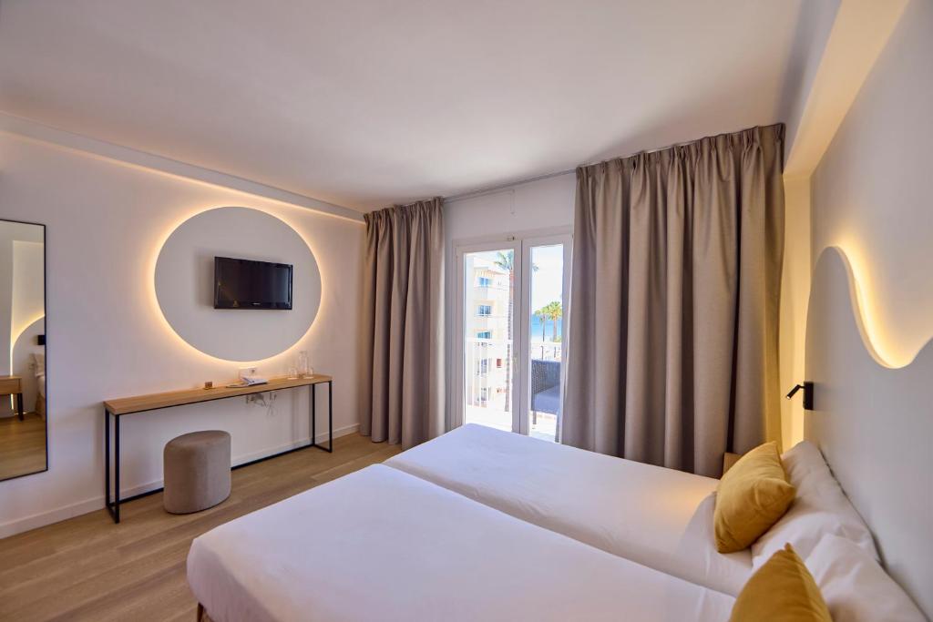 pokój hotelowy z dużym łóżkiem i oknem w obiekcie Universal Hotel Bikini w Cala Millor