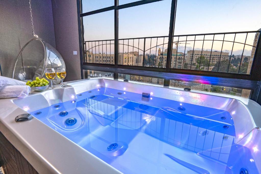 bañera grande en una habitación con ventana en Spa on the walls - Mamilla View - Jerusalem ספא על החומות ירושלים, en Jerusalén