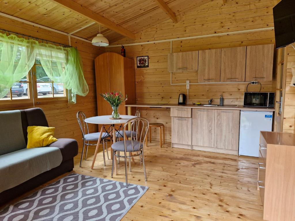 a kitchen and living room with a table and chairs at Domki Radków in Radków