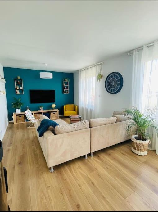 un salon avec deux canapés et une télévision dans l'établissement Maison familiale, à Pordic