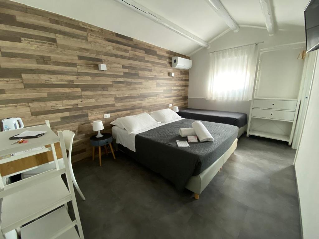 a bedroom with a bed and a wooden wall at Boutique Hotel Nuovo Cason in Cavallino-Treporti