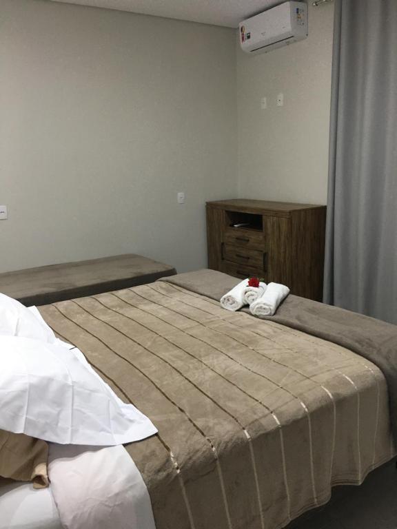 1 dormitorio con 1 cama con toallas en Pousada Lobo Guará, en São João Batista do Glória
