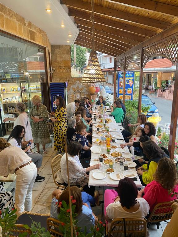 un groupe de personnes assises à de longues tables dans un restaurant dans l'établissement Costas Inn, à Spílion