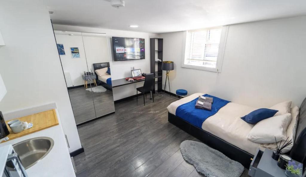 a bedroom with a bed and a sink and a bathroom at Modern Studio next to University of Birmingham in Birmingham