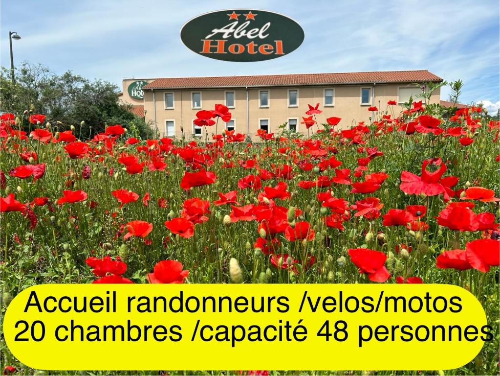 ein Feld mit rotem Mohn vor einem Hotel in der Unterkunft Abel Hôtel in Langeac