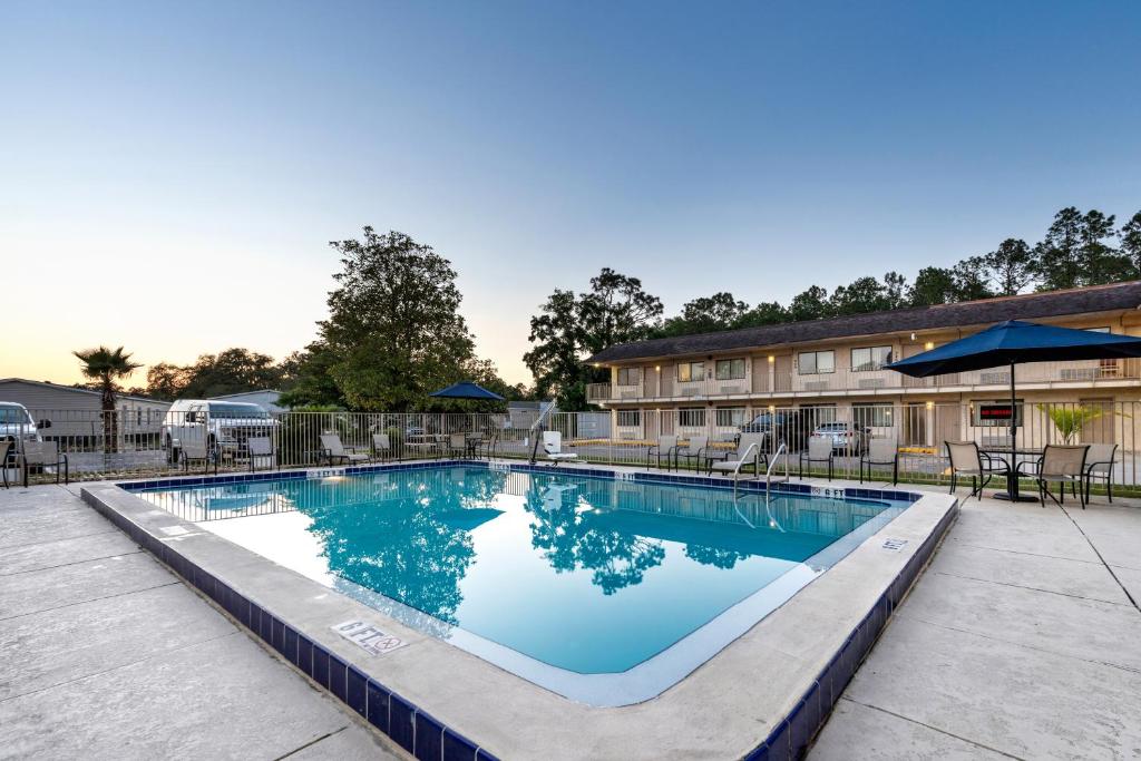 a swimming pool at a hotel with tables and chairs at Americas Best Value Inn - Lake City in Lake City