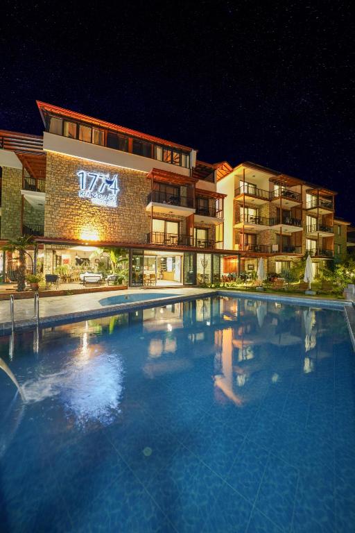 a large swimming pool in front of a building at night at 1774 Kazdağı Termal Otel in Ilija