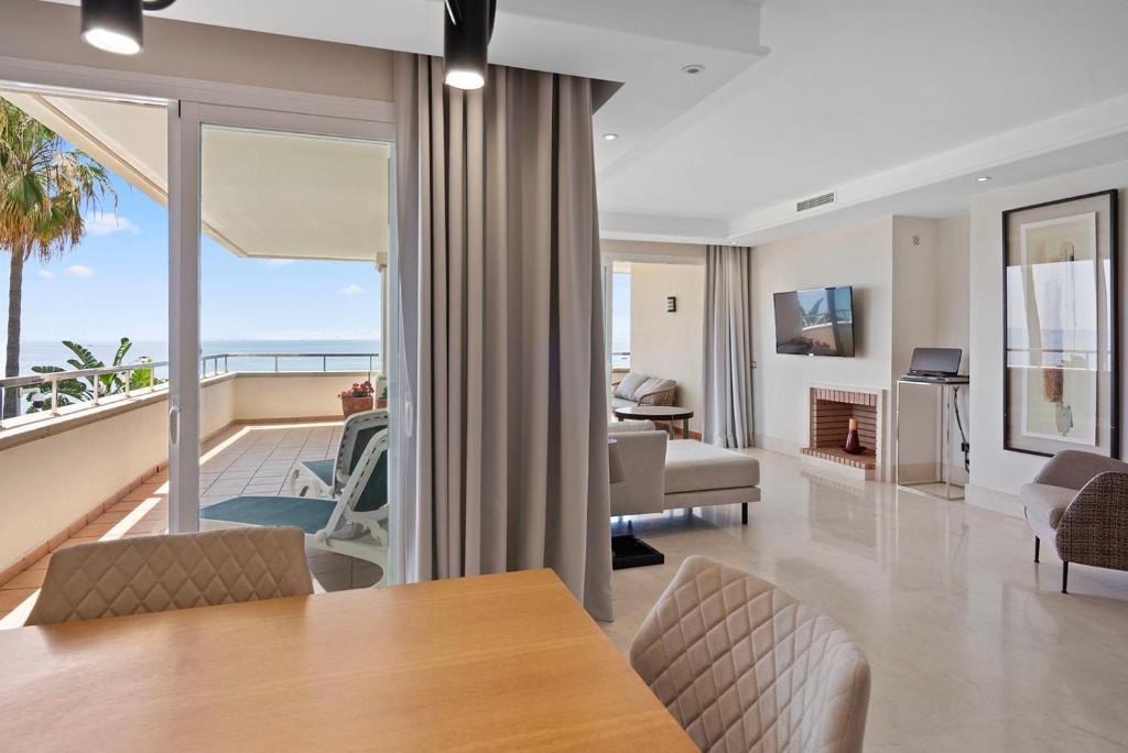salon ze stołem i widokiem na ocean w obiekcie Front line beach luxury apartment in Heaven Beach w mieście Estepona