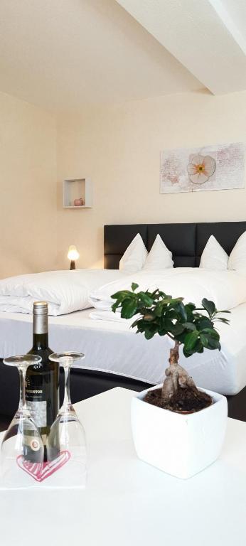 a bottle of wine and a plant on a table in a hotel room at Hotel Schneiderhof in Braunlage