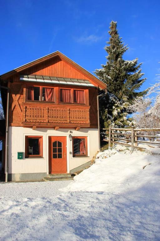 a house with a red door in the snow at Chalet Mariapfarr in Mariapfarr