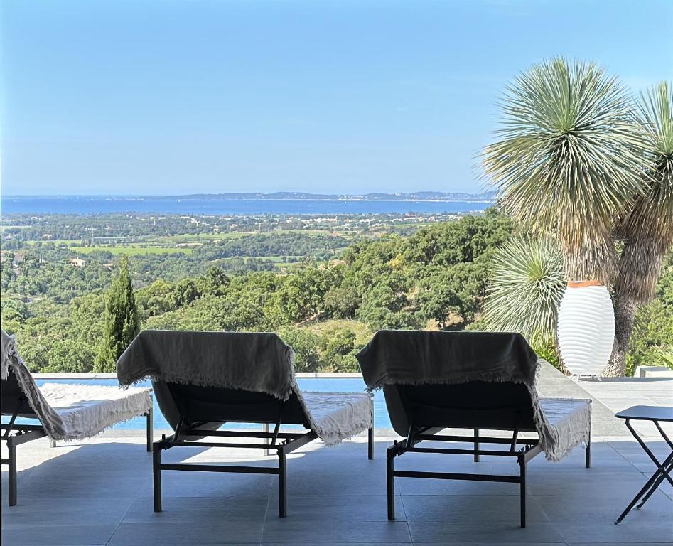 - un ensemble de chaises assises sur une terrasse avec vue dans l'établissement La Vigie, villa pour 8 personnes avec piscine chauffée et vue mer à La Londe-Les-Maures, à La Londe-les-Maures