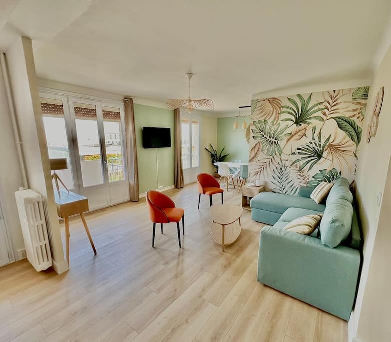 un salon avec un canapé bleu et des chaises dans l'établissement Spacieux T3 terrasse vue mer, à Sète