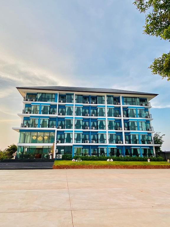 un grand bâtiment bleu avec beaucoup de fenêtres dans l'établissement Arunsakhon luxury condo, à Ban Khok Kham