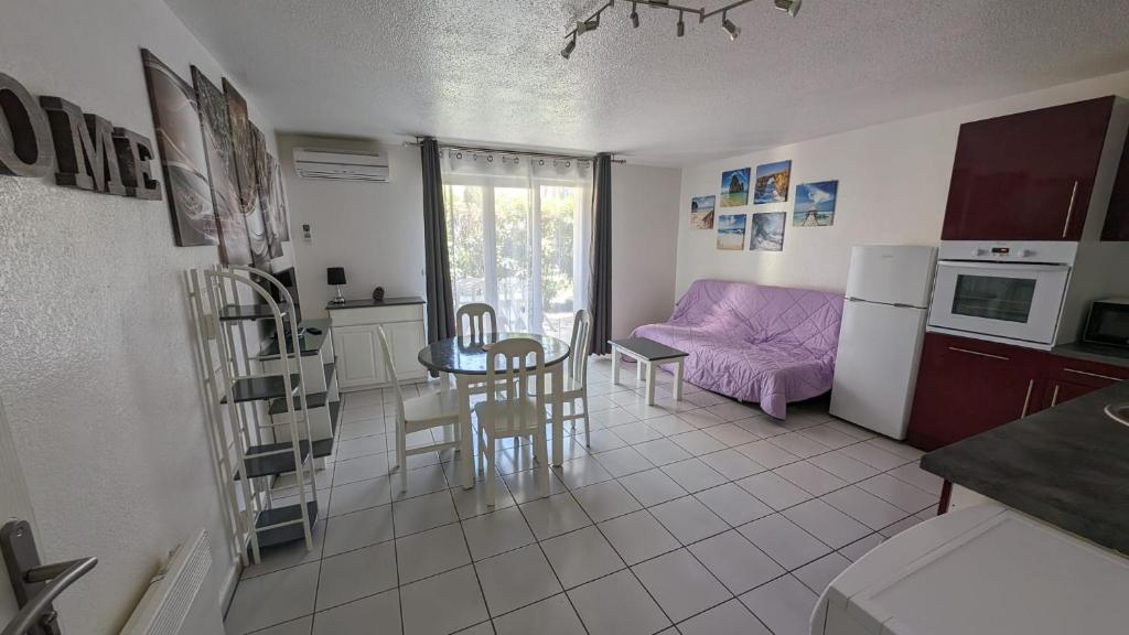 une cuisine et un salon avec une table et des chaises dans l'établissement Joli T2 - Emeraude 28, à Canet