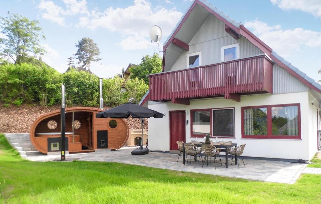 una casa con patio e ombrellone di Ferienhaus 107 In Kirchheim a Kemmerode
