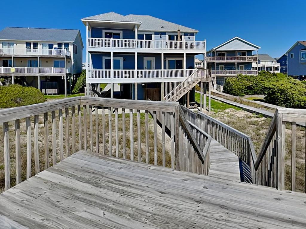 a wooden boardwalk leading to a beach house at Bela Casa in Surf City