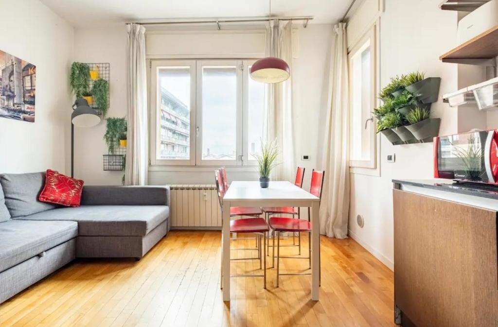 salon ze stołem i kanapą w obiekcie Casa Bolognese - in the heart of the city! w Bolonii