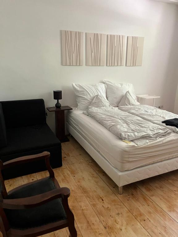 ヴァーチにあるKisudvaros Apartmanのベッドルーム(白いベッド1台、椅子付)
