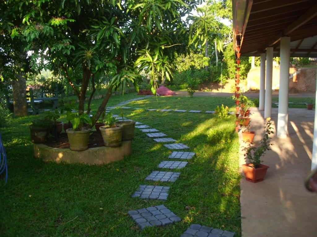 un jardín con una pasarela con árboles y plantas en Mount View Villa Resort Mirissa, en Mirissa