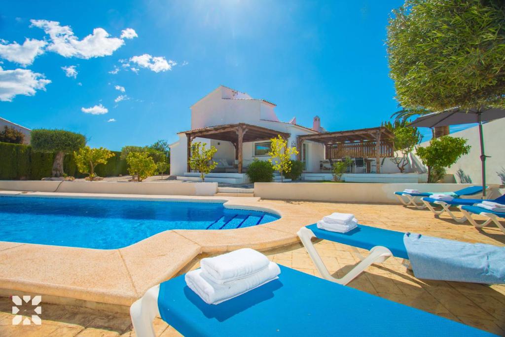 basen z leżakami i dom w obiekcie Villa Los Almendros by Abahana Villas w mieście Calpe
