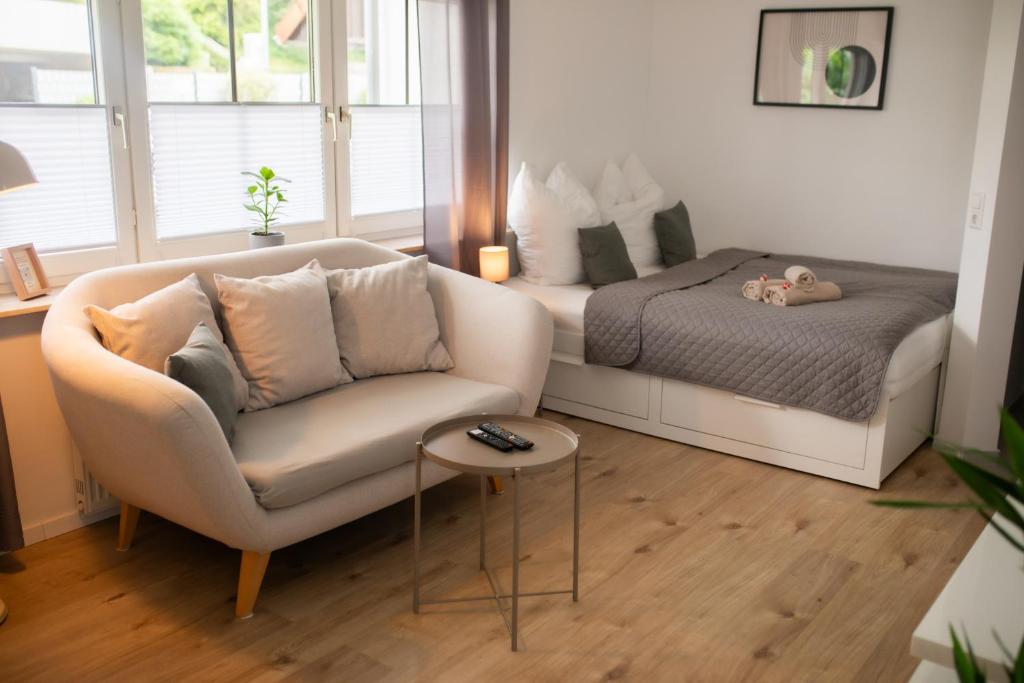 a living room with a bed and a couch and a chair at HUGOS Studio Apartment in Wiesloch
