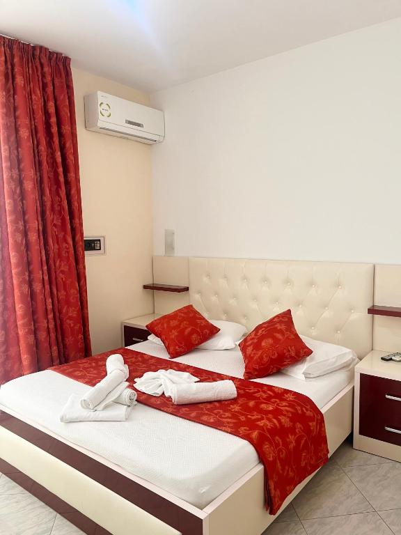 a hotel room with two beds with red and white towels at Hotel Garden in Vlorë