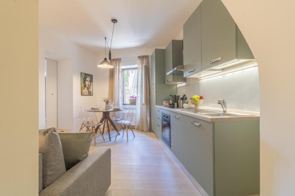 a kitchen and living room with a sink and a couch at Domus Viterbo Centro in Viterbo