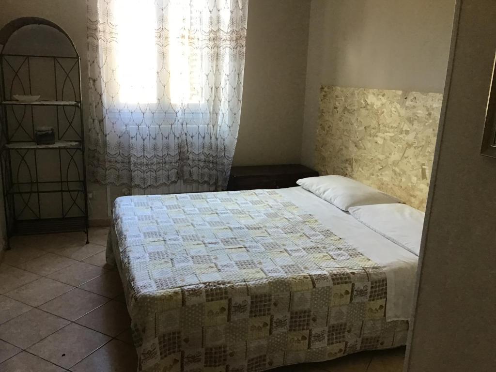 um quarto com uma cama e uma janela em Achirina bed and breakfast em Cisterna di Latina