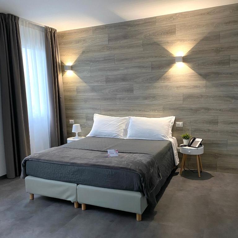 a bedroom with a bed and a wooden wall at Boutique Hotel Nuovo Cason in Cavallino-Treporti