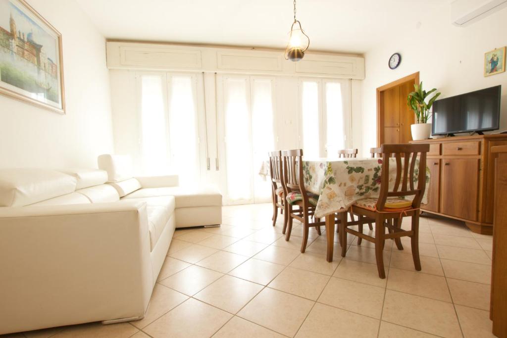 - un salon avec un canapé, une table et des chaises dans l'établissement 12 Accesso - Home Immobiliare Jesolo, à Lido di Jesolo