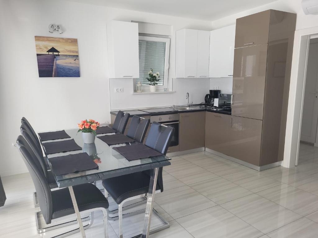 kuchnia ze stołem i krzesłami oraz kuchnia z blatem w obiekcie Apartment Villa Lumada with Pool w Novalji