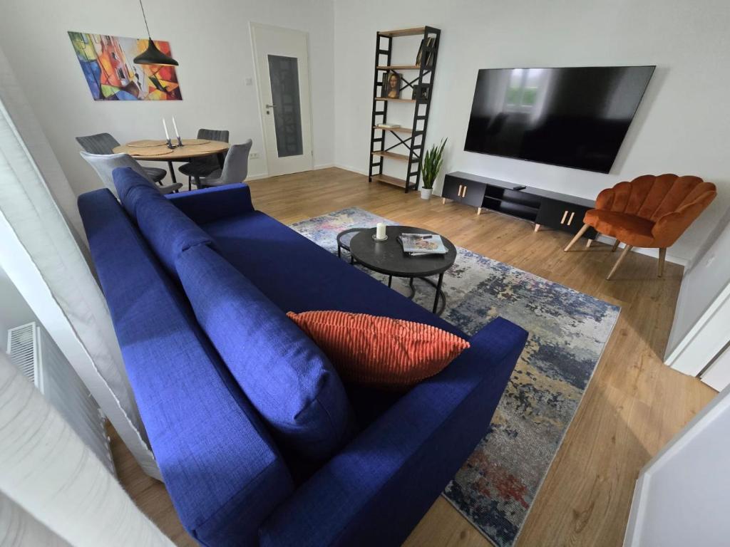 uma sala de estar com um sofá azul e uma televisão em Central stylish apartment em Braunau am Inn