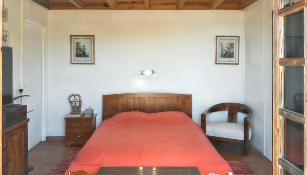 a bedroom with a red bed and a chair at Studio avec vue sur la mer piscine partagee et jardin clos a La Montagne in La Montagne