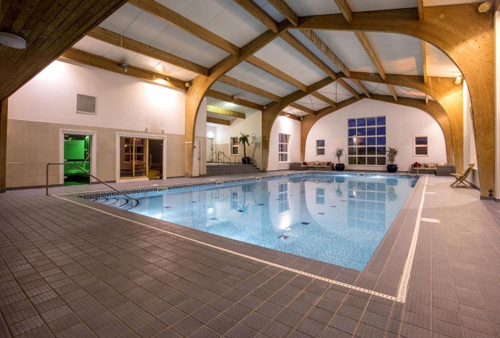 uma piscina interior com um tecto grande em The Old Hall Hotel em Caister-on-Sea