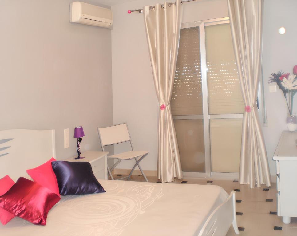 een slaapkamer met een bed met rode kussens en een raam bij 3 bedrooms villa with private pool and wifi at Benicarlo in Benicarló