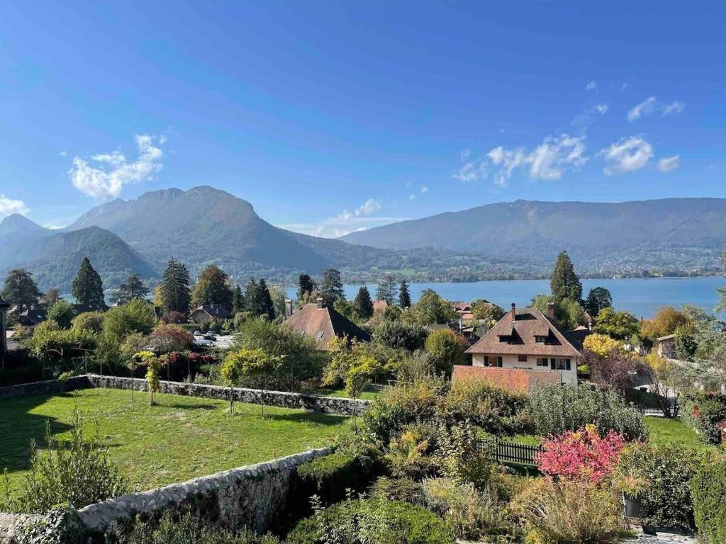 wioska z jeziorem i górami w tle w obiekcie Appartement avec Jardin & vue Lac Talloires (15' Annecy) w mieście Talloires