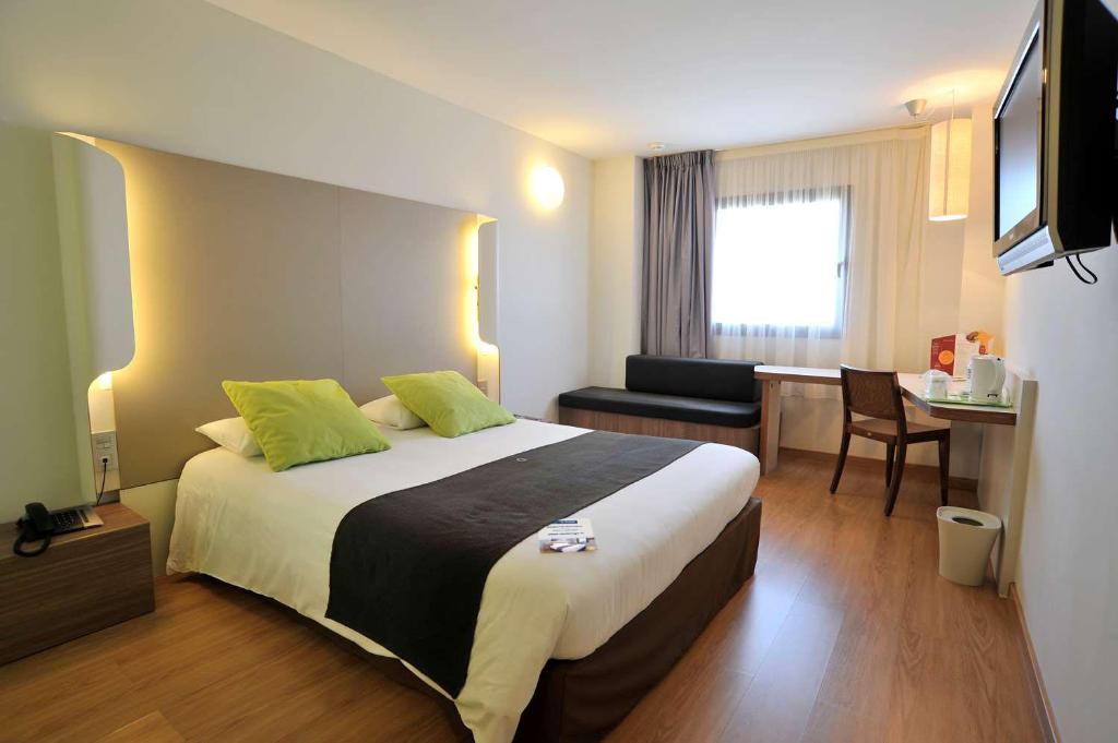 Habitación de hotel con cama grande y escritorio. en Travelodge Málaga Airport en Málaga