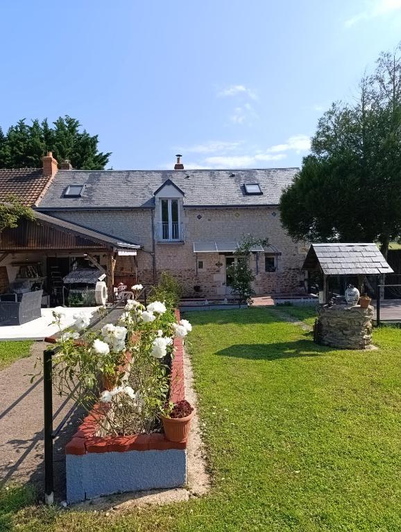 a house with a garden with flowers in a yard at Gîte : Le Castel des Anges in Marigny-Marmande
