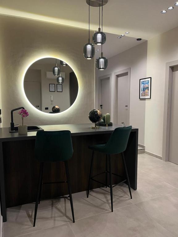 a room with a counter with two chairs and a mirror at Stay in Naples in Naples