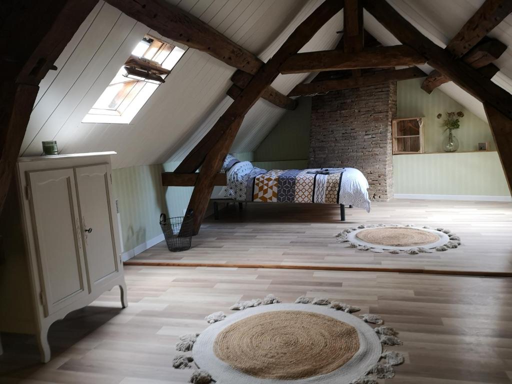 une chambre mansardée avec un lit et deux tapis au sol dans l'établissement Maison Familiale à 5 min de LaON, à Vorges